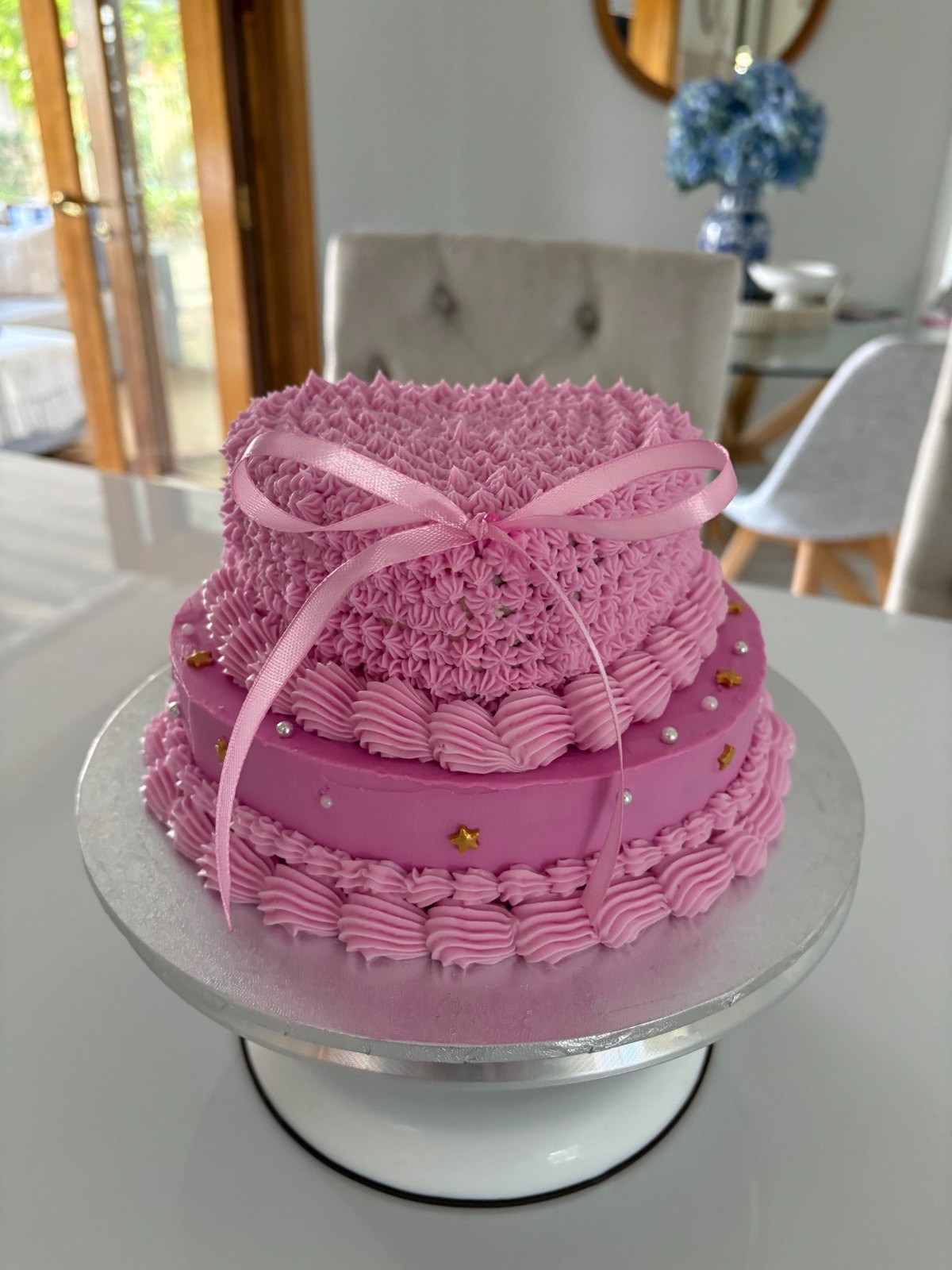 Pink vintage piped celebration cake with ribbon bow